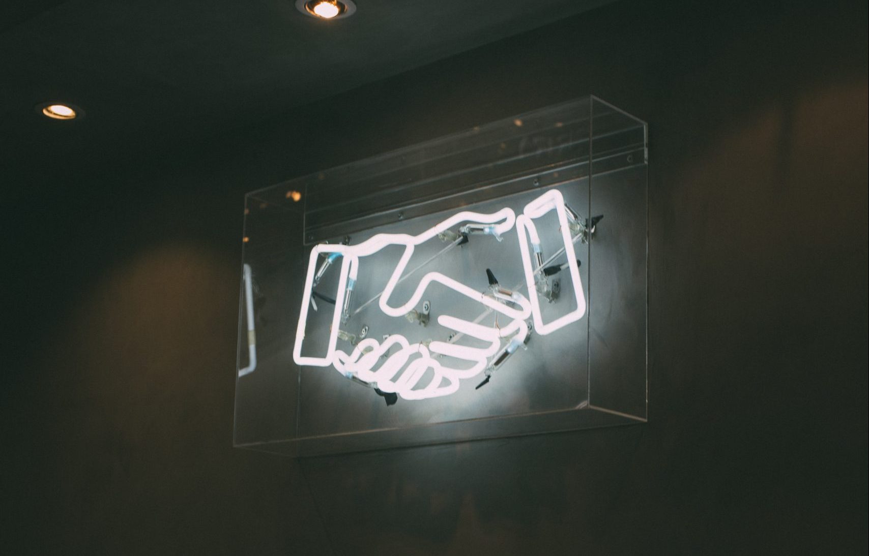 neon art in the shape of a handshake
