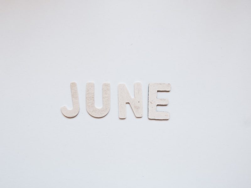 'June' written using paper cut letters, over a white background