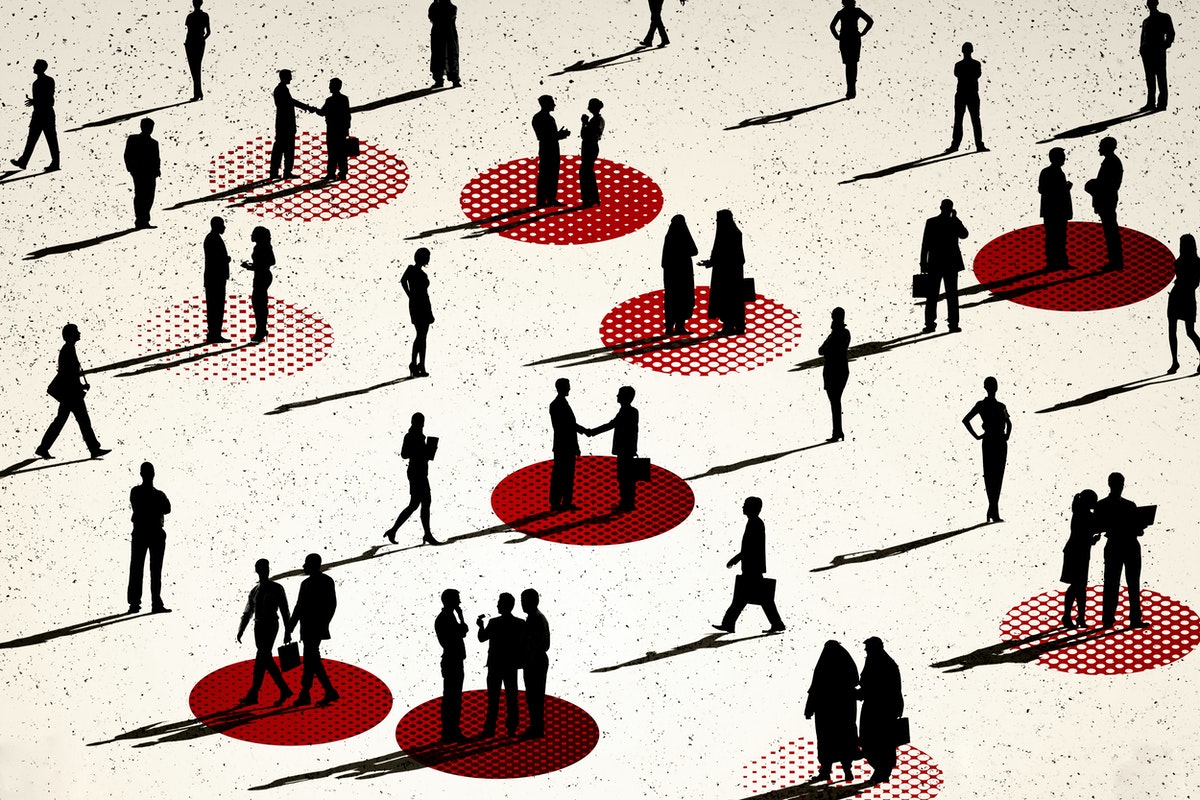 lots of people seen from afar, we can only see their profiles in black. some of them are talking to each other, some are walking. there is some distance between everyone, and some small groups stand over red circles painted on the floor.