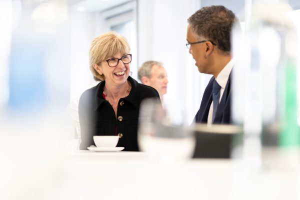 A woman and a man are sat at a table having a conversation